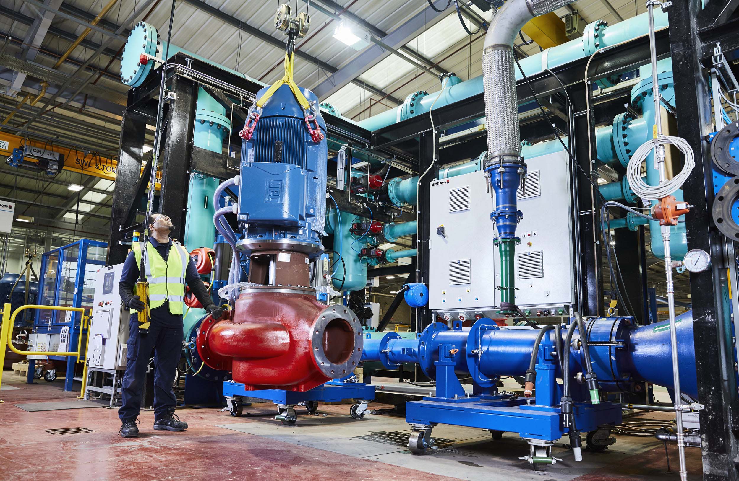 a worker winching a pump on to a test rig amrmstrong manchester